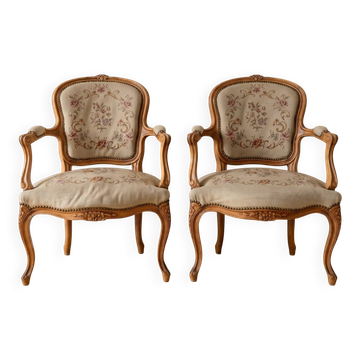 Pair of Louis XV/XVI armchairs in carved wood and floral fabric.