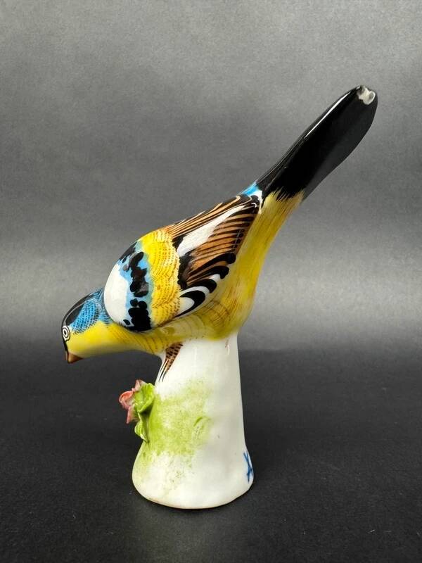 Porcelain figurine of a polychrome bird on a vintage floral base