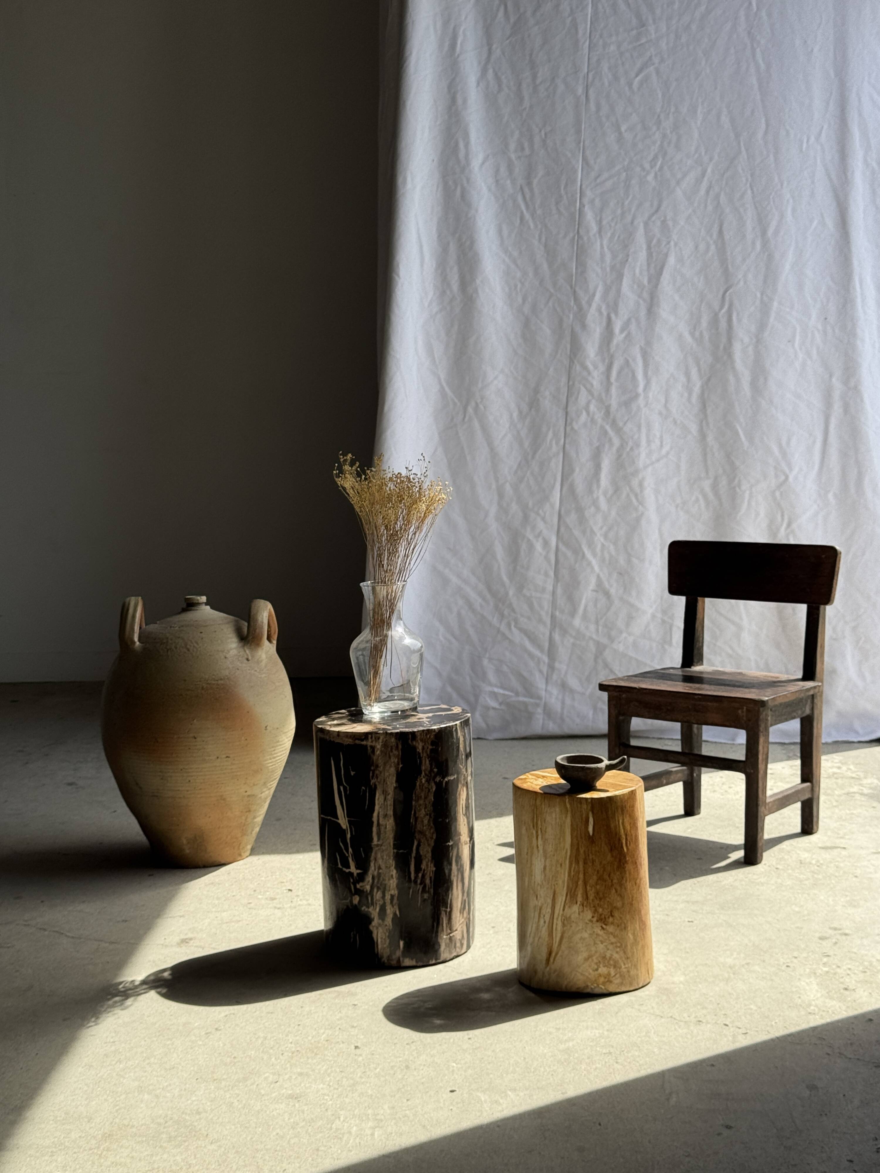 Black petrified wood side table with beige stripes and a semicircular shape.