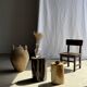 Black petrified wood side table with beige stripes and a semicircular shape.