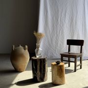 Black petrified wood side table with beige stripes and a semicircular shape.