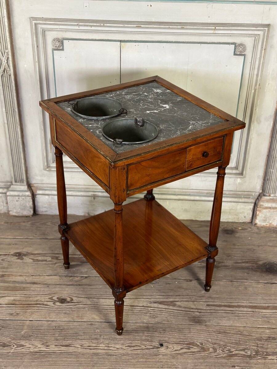 Refreshment table in mahogany, grey marble top, two zinc buckets, 18th century.