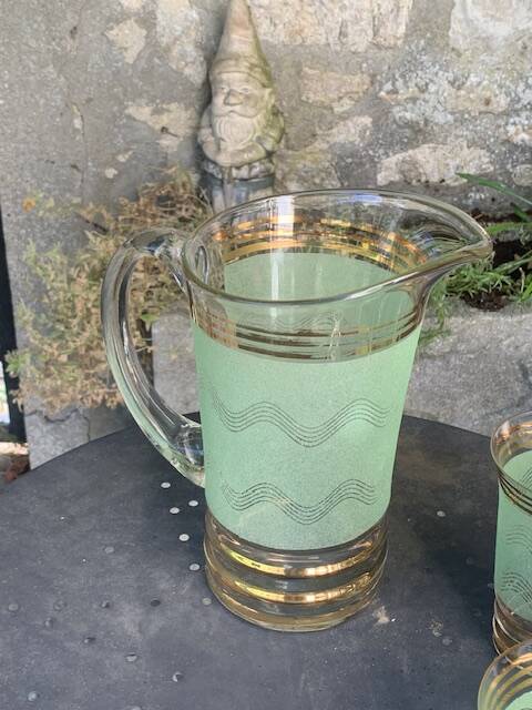 Serve an orangeade, a carafe and 3 glasses in green granite with golden trim.