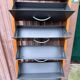 Scandinavian shoe storage cabinet in grey wood and metal.