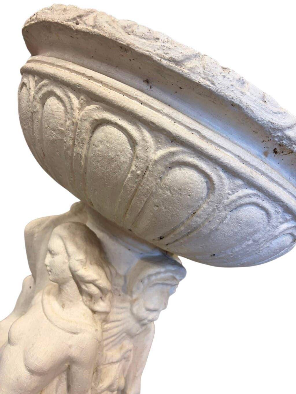 Vintage white concrete garden statue adorned with planter.