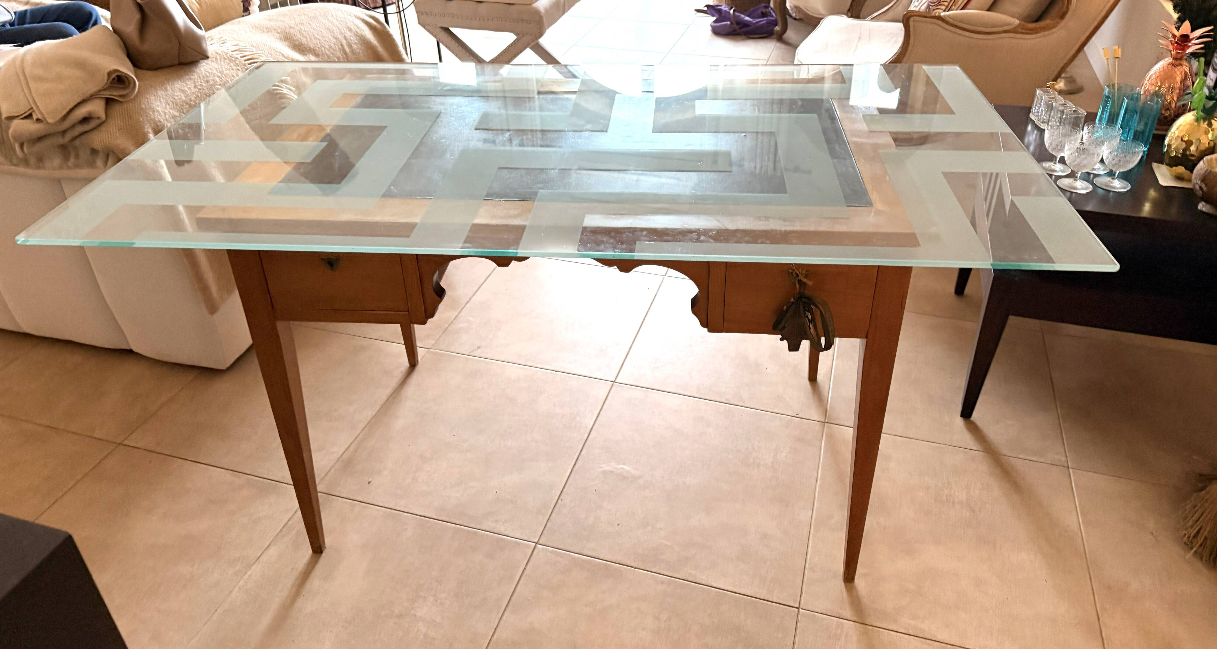 Elegant antique desk in cherry wood with a black leather top and glass plate.