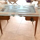 Elegant antique desk in cherry wood with a black leather top and glass plate.