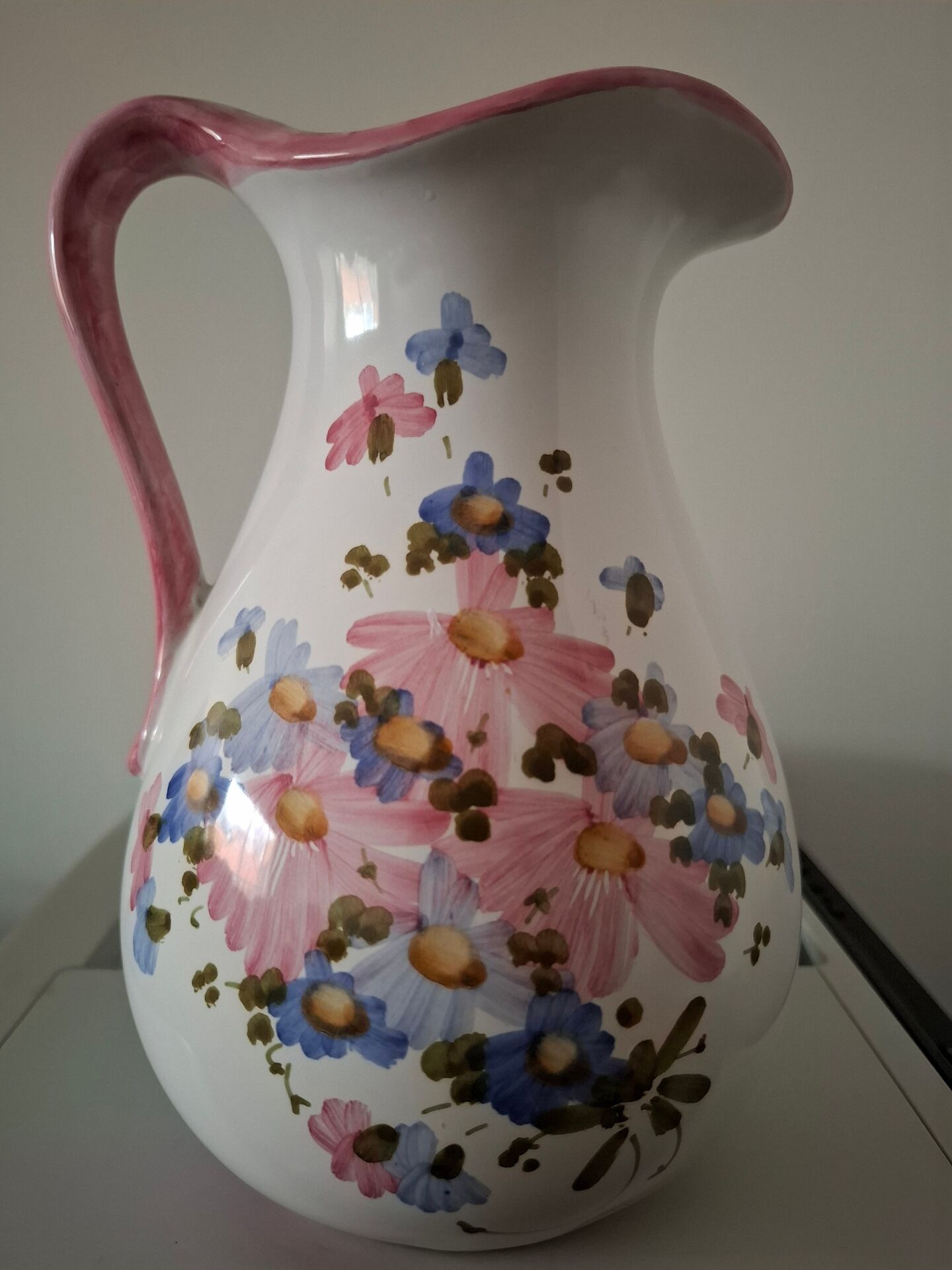 Old ceramic pitcher with floral decoration.