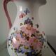 Old ceramic pitcher with floral decoration.