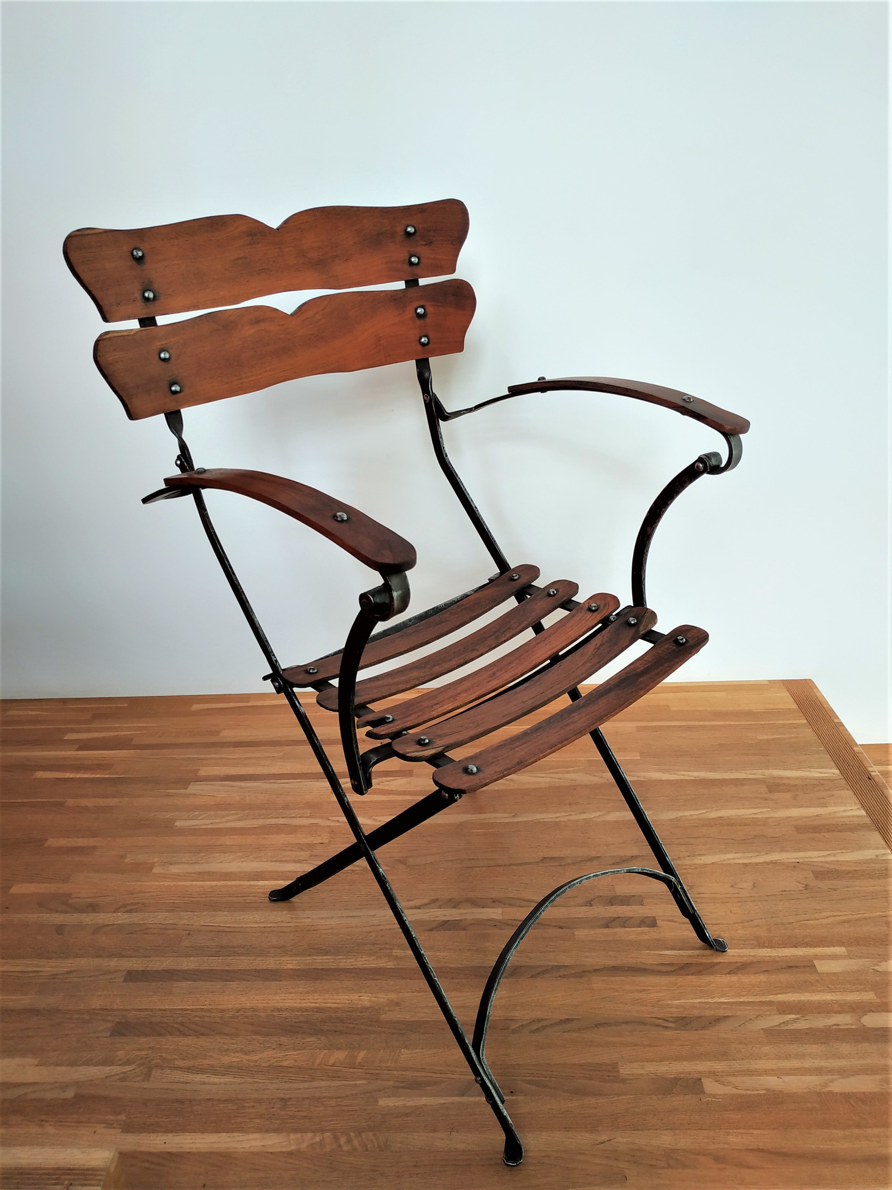 Folding garden chair with teak slats on a wrought iron structure