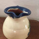 Terracotta jug with grape decoration.