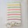 Moroccan plaid made of handwoven wool, decorated with stripes and pom poms.