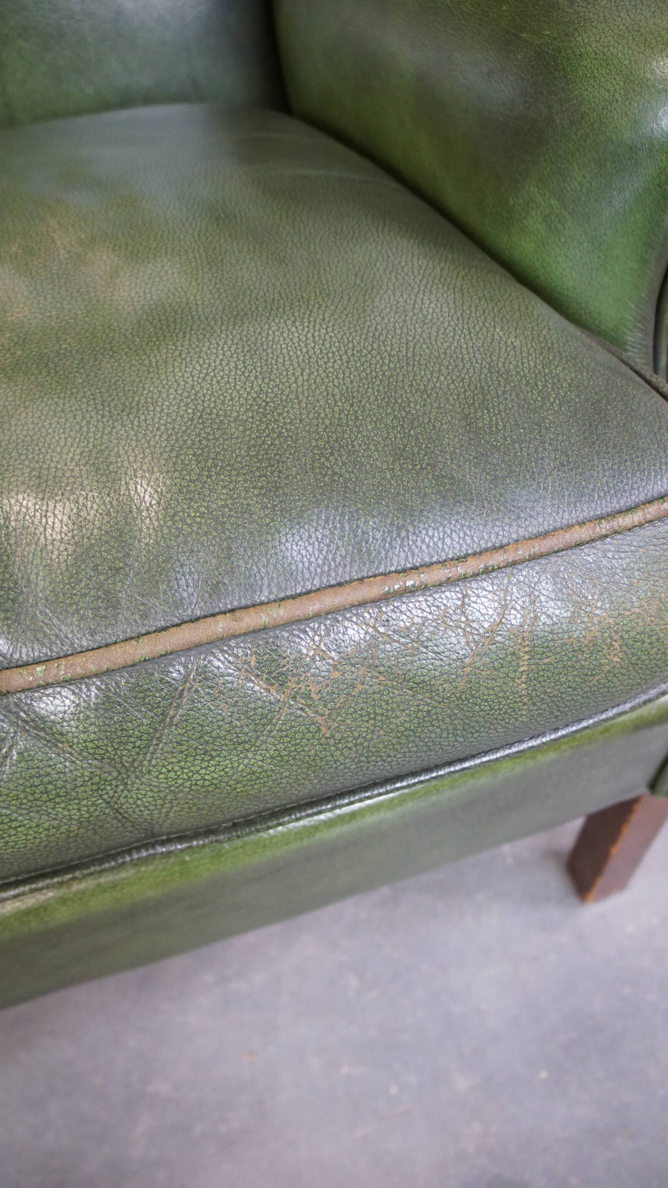 Fauteuil à oreilles Chesterfield anglais en cuir de vache vert avec une assise confortable