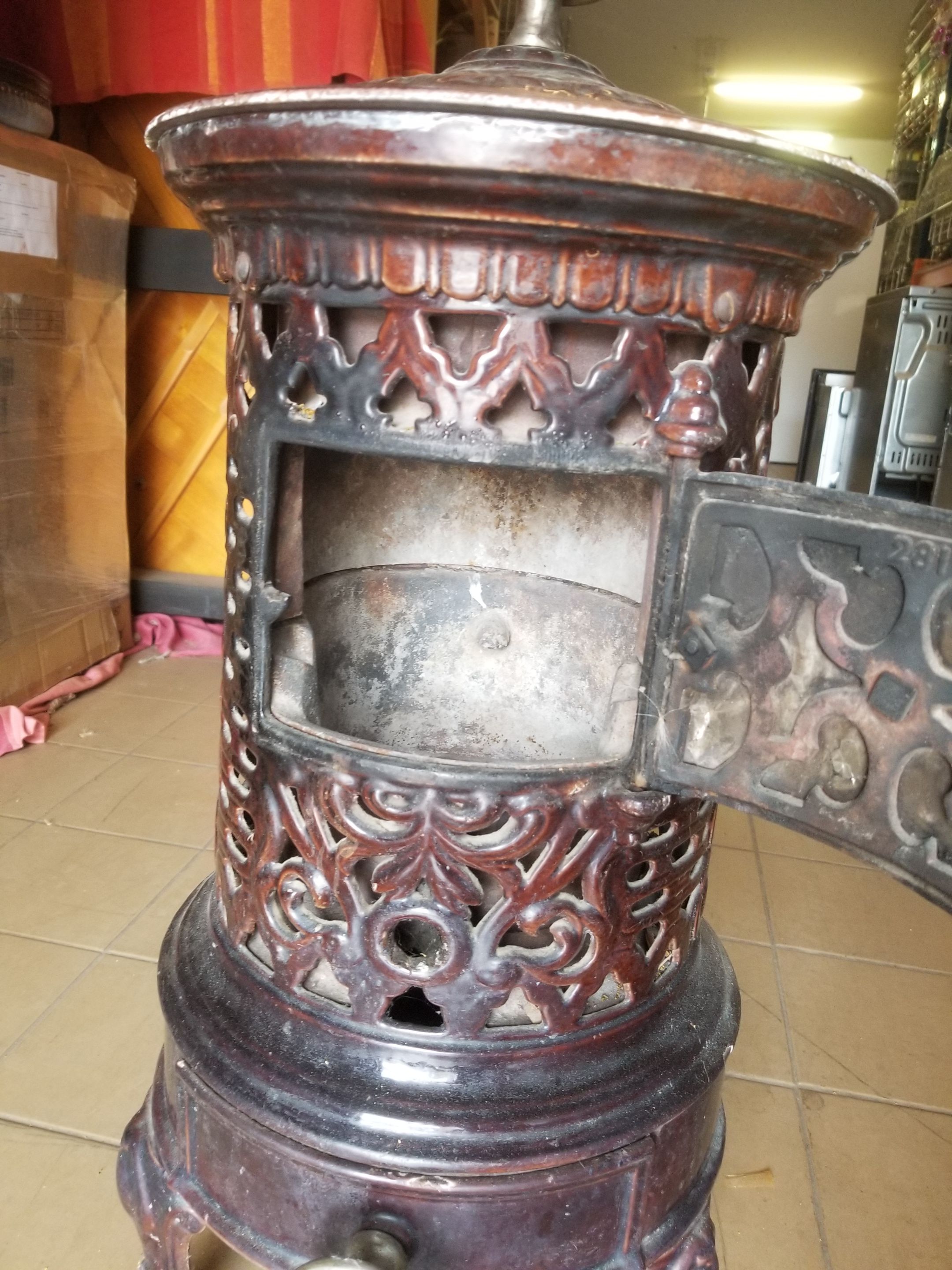 Old compact wood stove in enamelled cast iron with tripod feet with Lion's legs