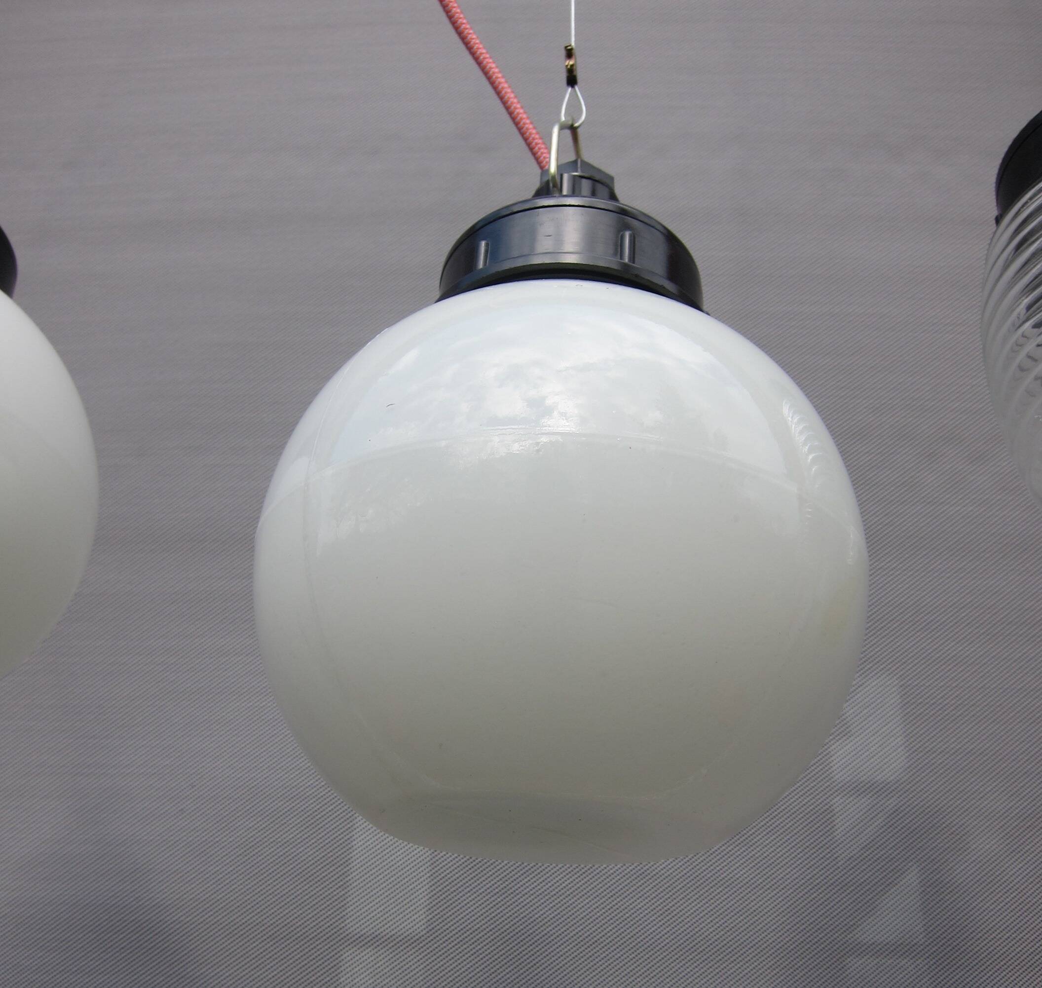Trio of opal glass and bakelite globe pendant lights