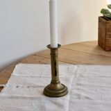 Antique brass candlestick with a push button.