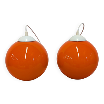 Pair of spherical pendant lights in orange opaline, France circa 1970.