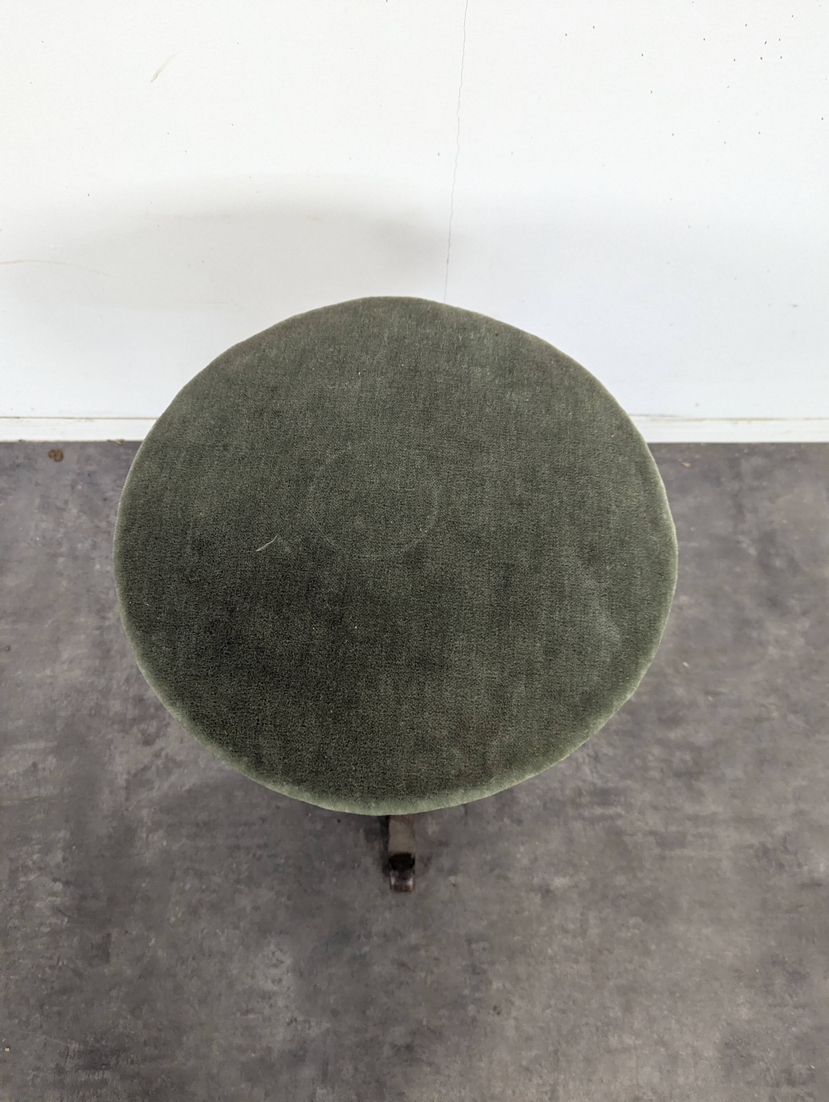 Green velvet piano stool with a turned leg.