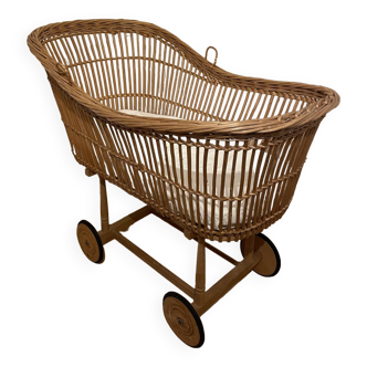 Vintage rattan baby cradle on wheels