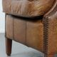 Cognac-coloured wingback armchair in English style made of cowhide leather