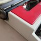 Typewriter "Burelec 315" made in Spain in red and white metal.