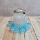 An antique lampshade in frosted glass with delicate blue edges.