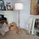 Vintage floor lamp in turned wood with an aged effect.