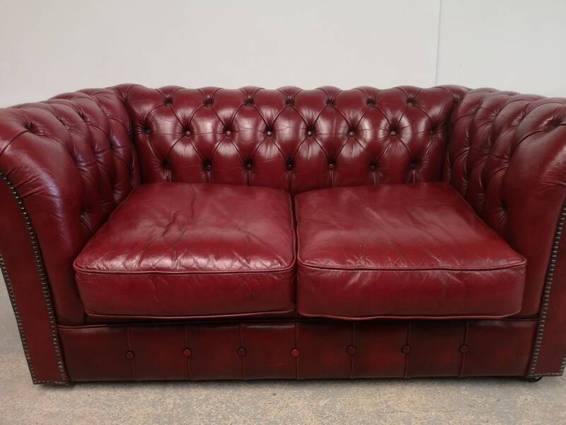Red two-seater chesterfield sofa