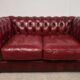 Red two-seater chesterfield sofa
