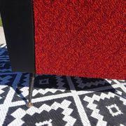 Pair of vintage armchairs in black faux leather and red fabric.