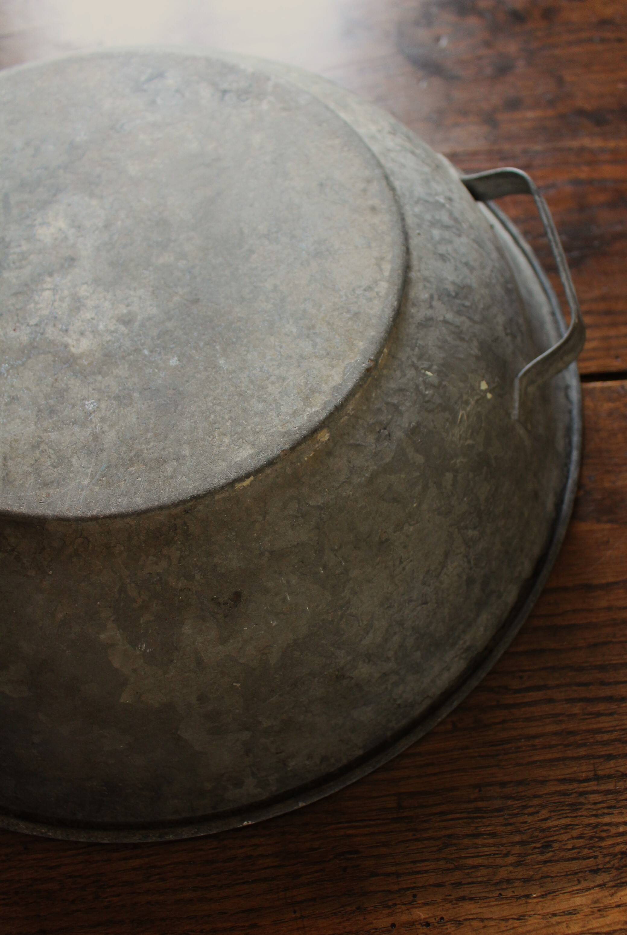 Round zinc basin planter with two handles underneath