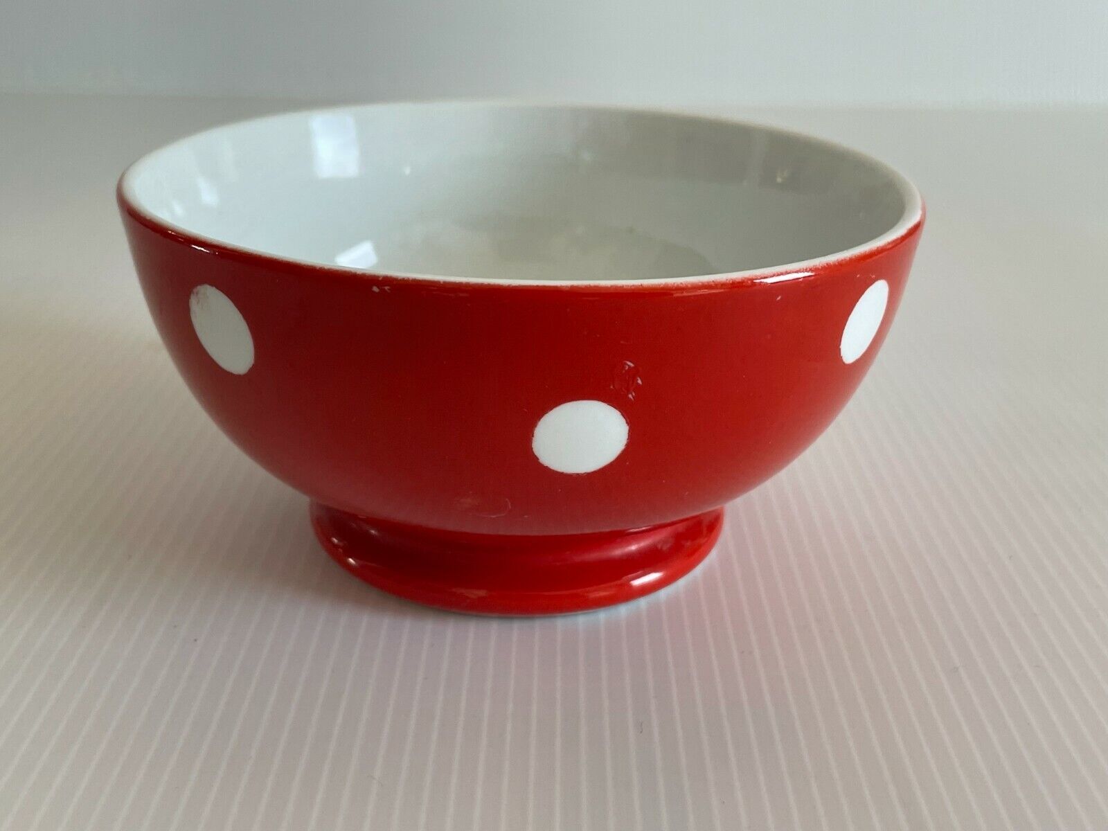 Red bowl with white polka dots signed Longchamp Porcelaine France
