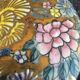 Porcelain candy with enamelled floral decorations. Pretty colors on a golden background.