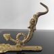 Vintage brass coat hook with marine creature motif and medallion.