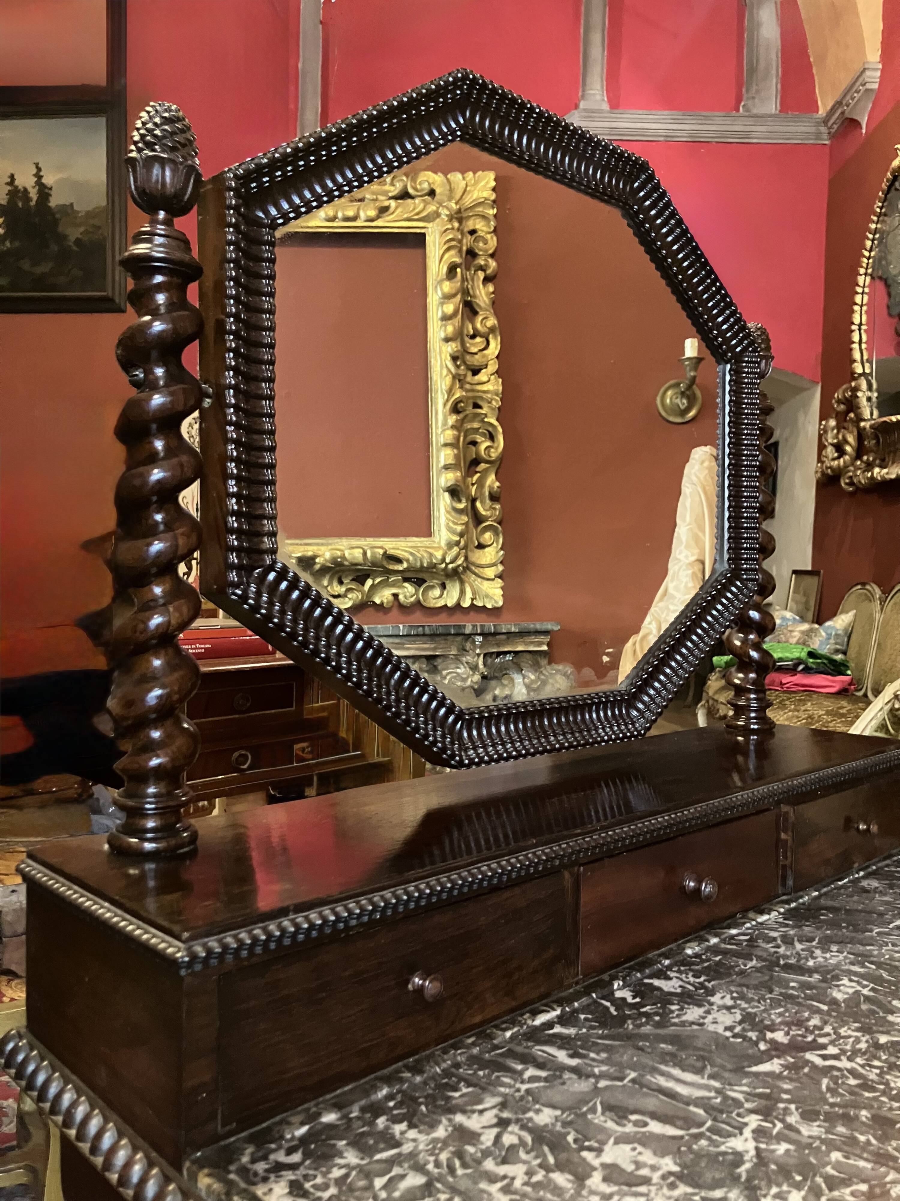 Antique English mahogany dressing table with carved details, black marble, and mirror.