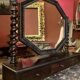 Antique English mahogany dressing table with carved details, black marble, and mirror.