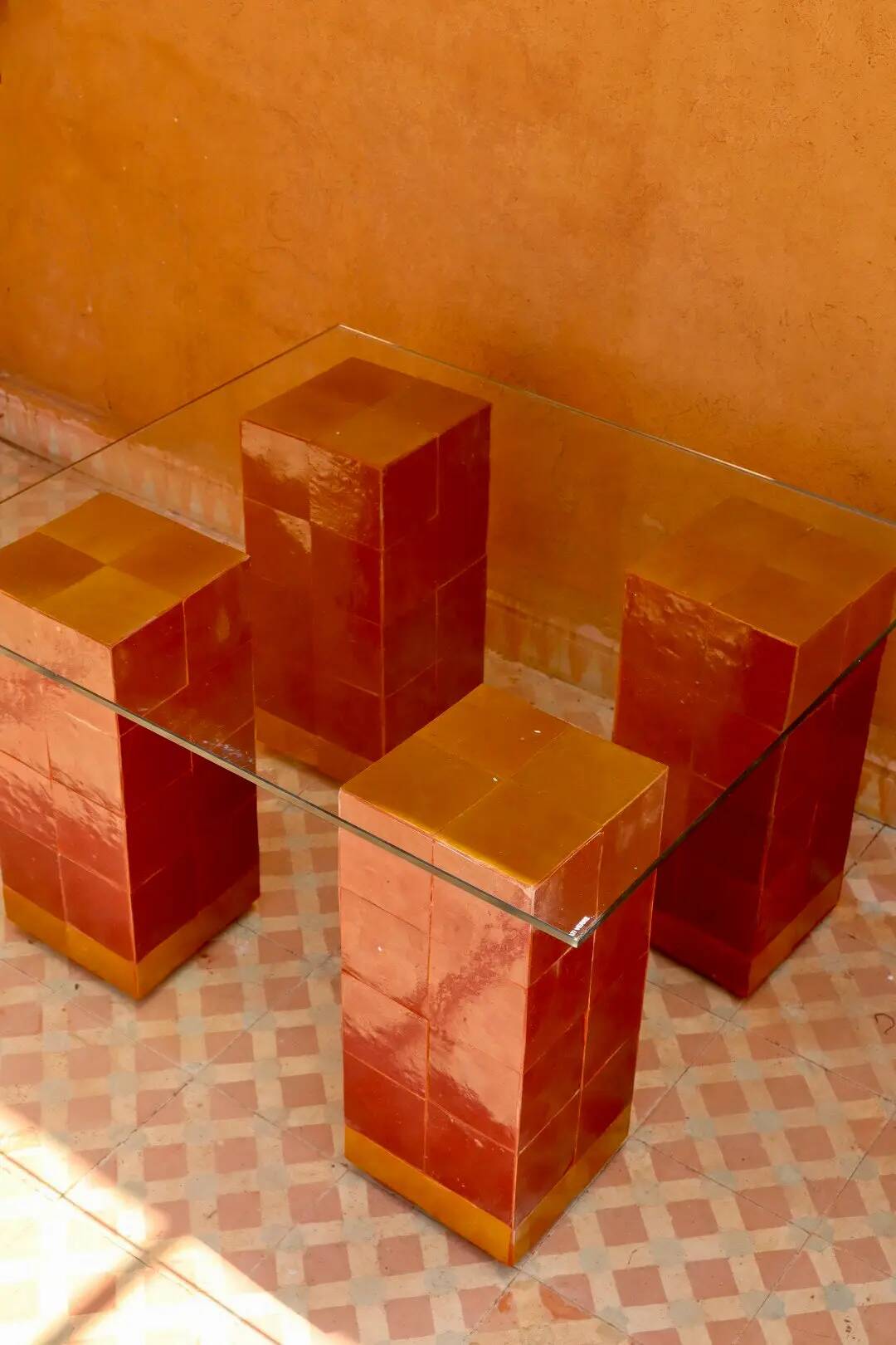 Modern coffee table in burgundy zellige with a tempered glass top.