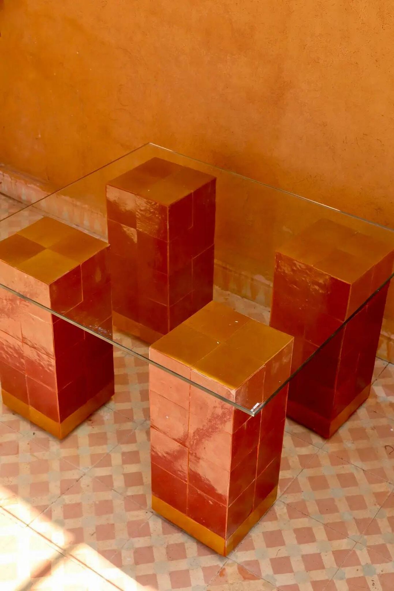 Modern coffee table in burgundy zellige with a tempered glass top.