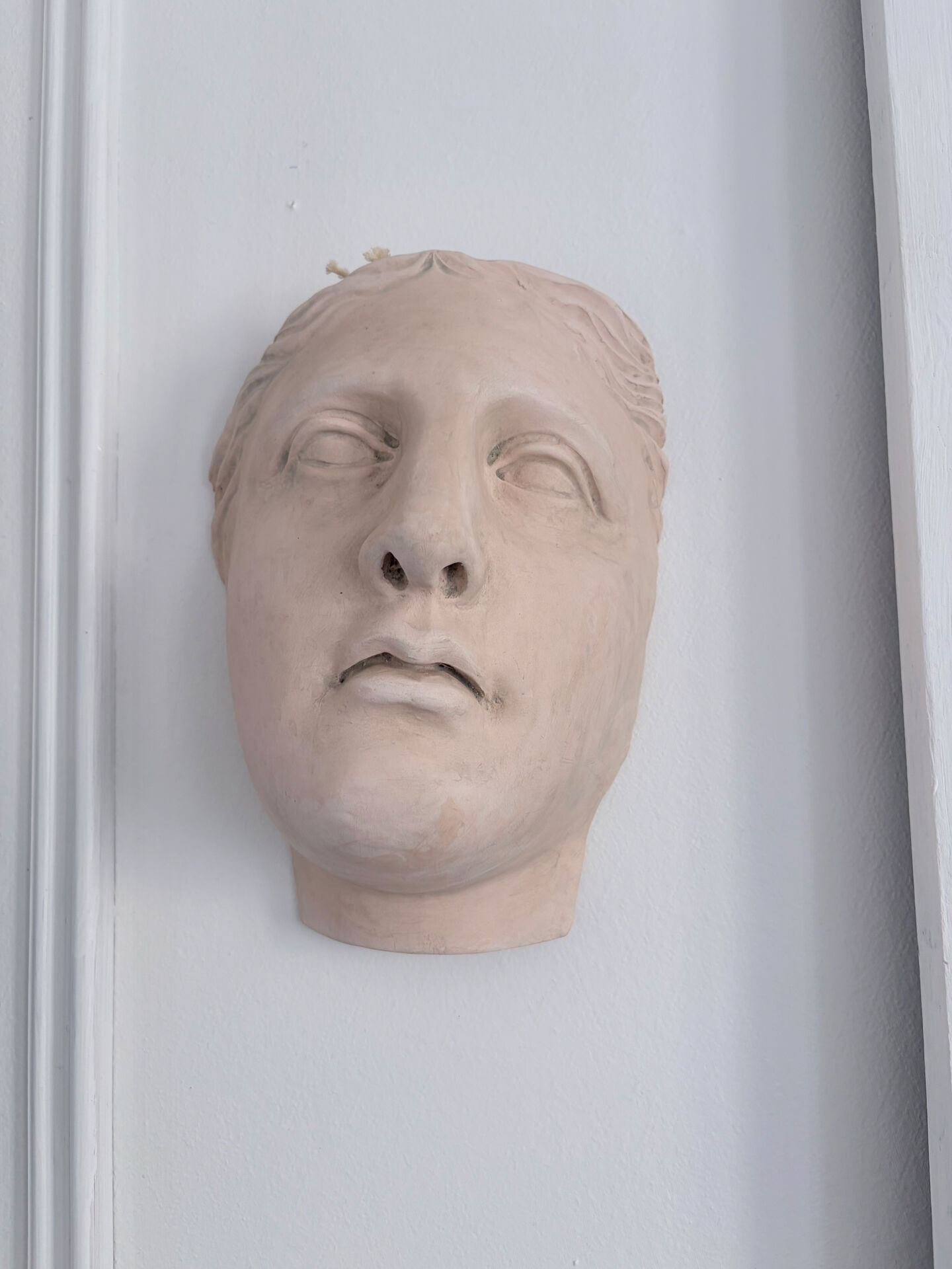 Wall sculpture of the face of the Venus de Milo in plaster.