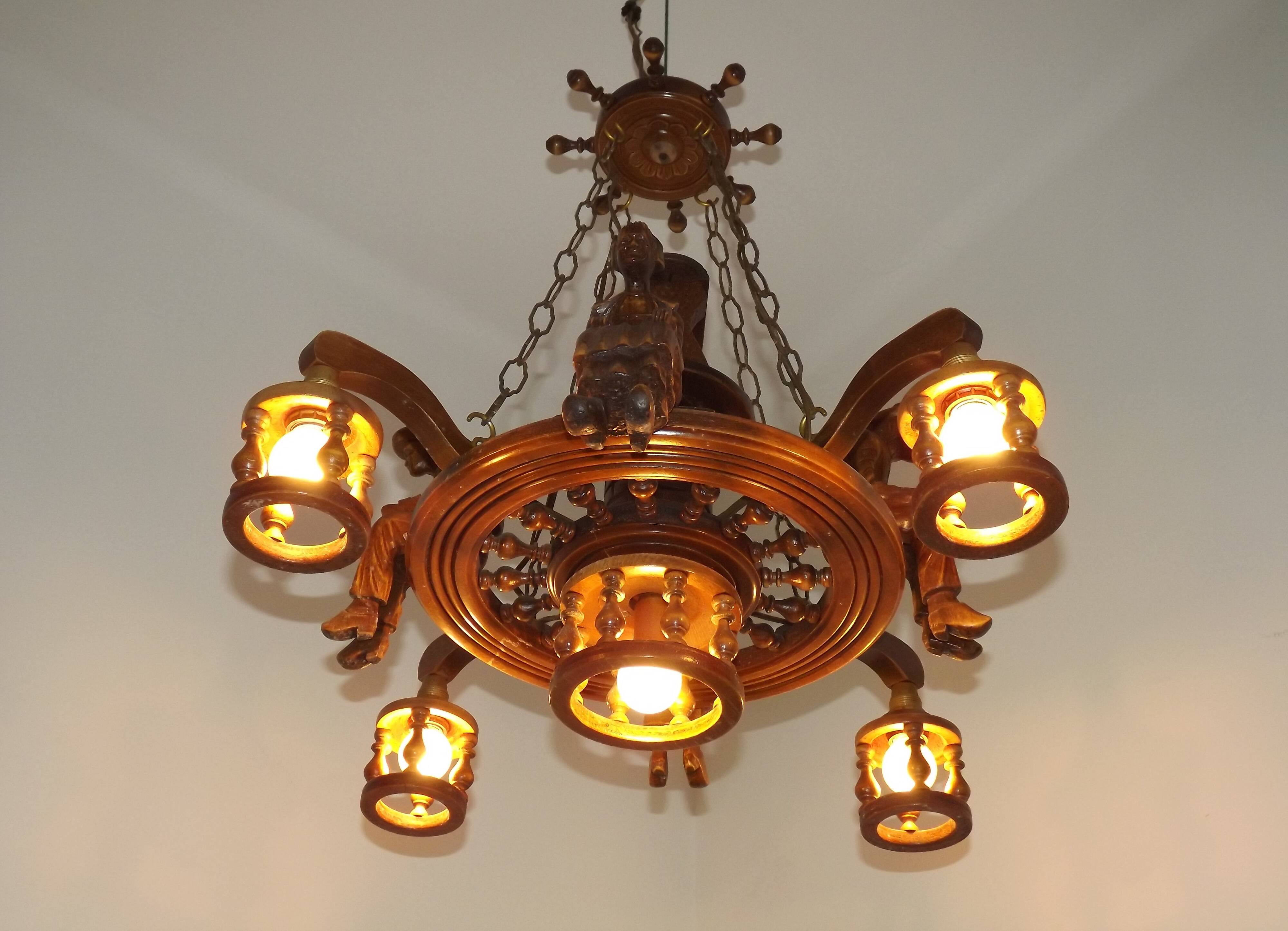 French vintage Breton chandelier with hand-carved figures, well, and lantern lights.