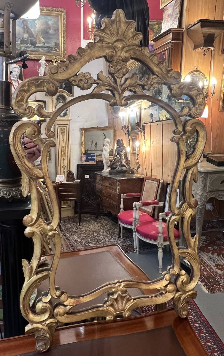 Mirror with carved and gilded wooden frame, 18th century, with scrollwork decoration.