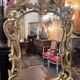 Mirror with carved and gilded wooden frame, 18th century, with scrollwork decoration.