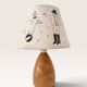 Wood-turned lamp with a hand-drawn lampshade, circus patterns.