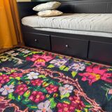 Bohemian floral design, handwoven wool rug, black background with colorful flowers