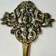Decorative coat hook with cherubs/putti in aged brass.