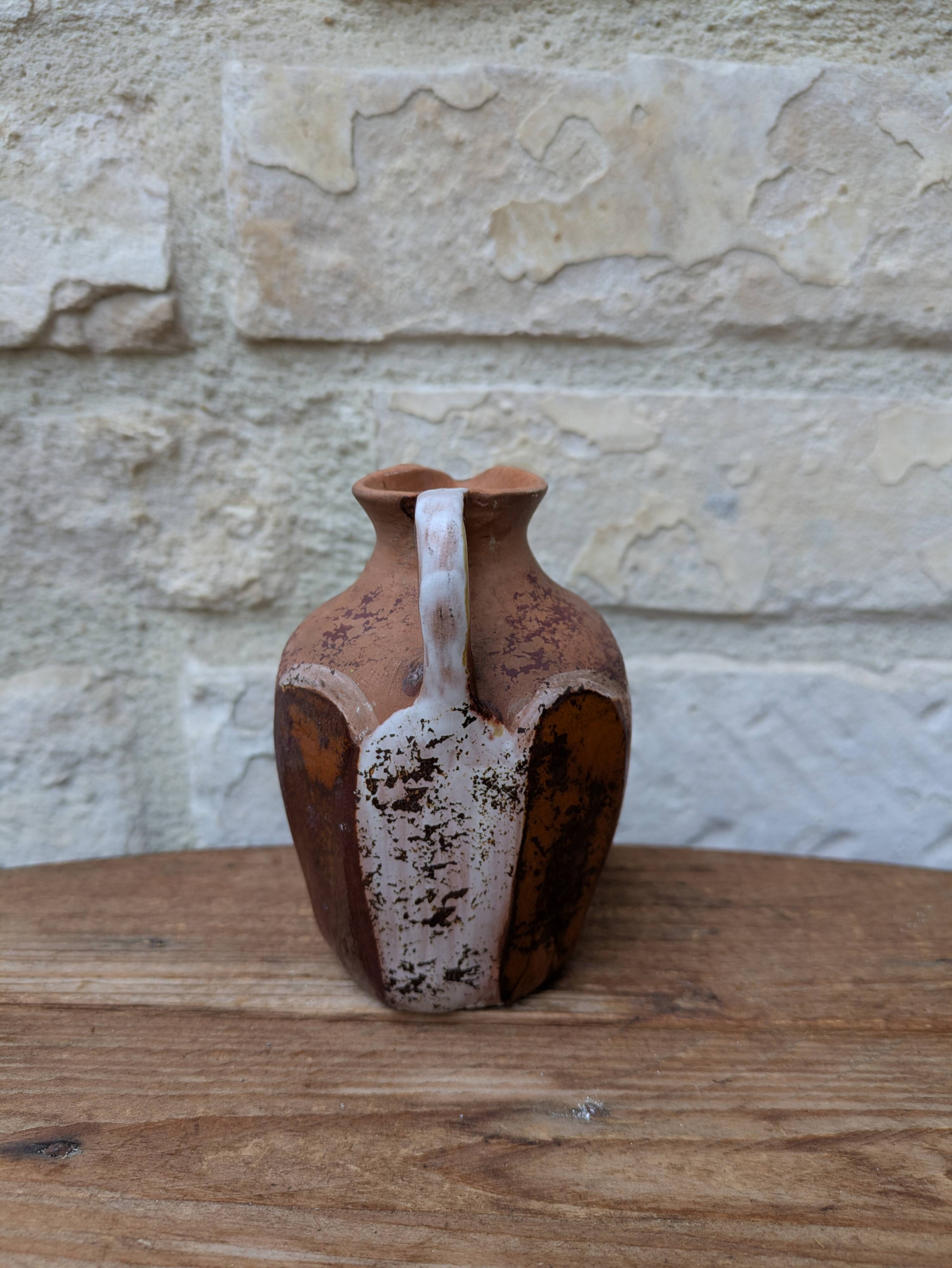 Old small pitcher in glazed terracotta