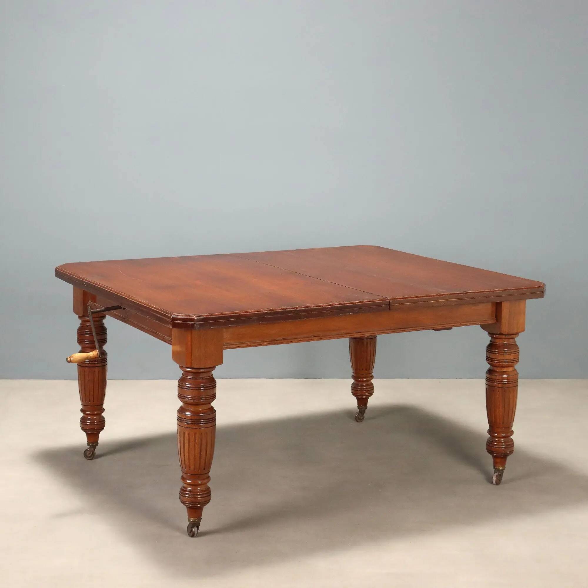 Antique extendable mahogany table with a crank mechanism, United Kingdom.