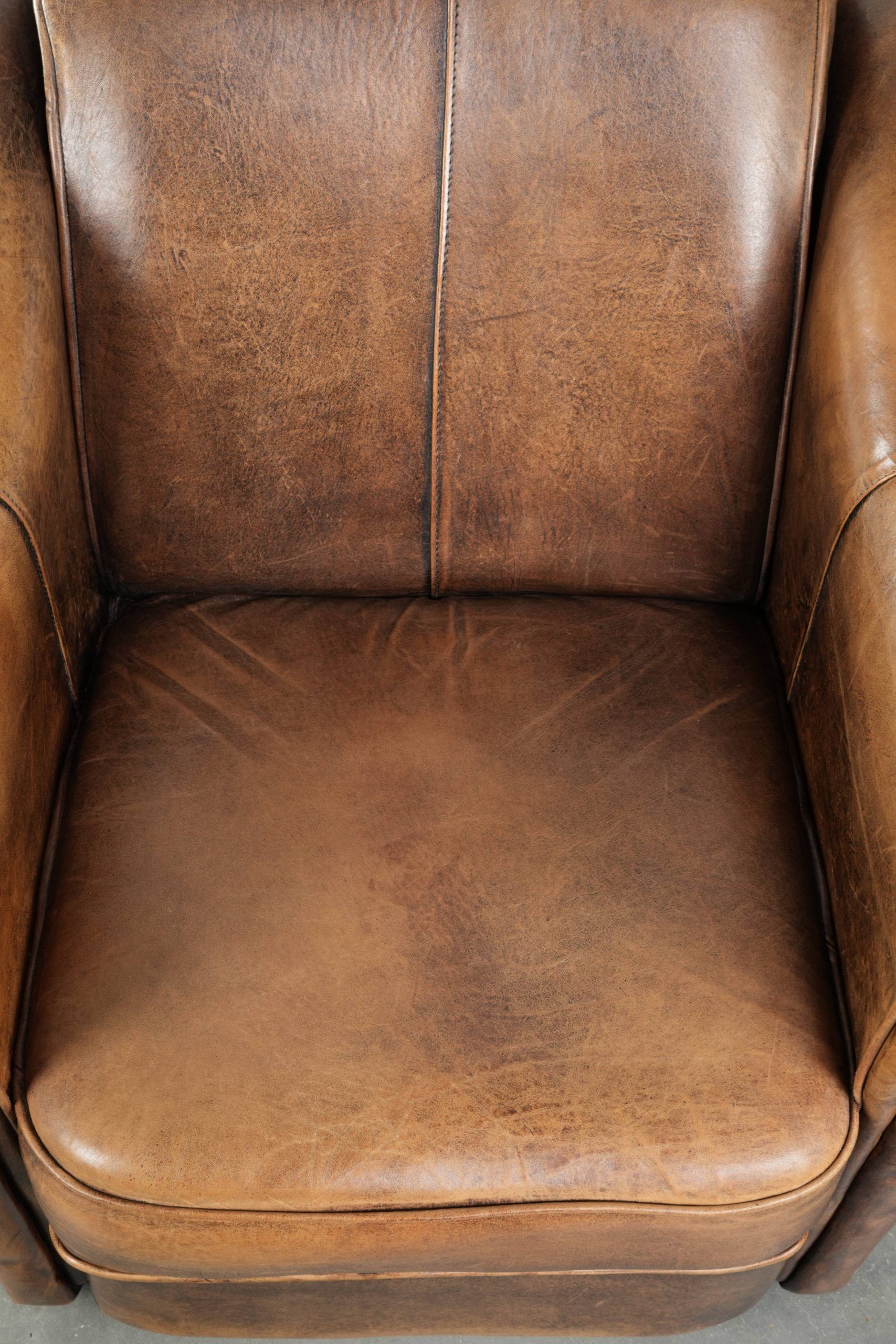 Fauteuil en peau de mouton magnifiquement conçu et confortable, avec un look intemporel et une finition de passepoil assortie.