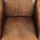 Fauteuil en peau de mouton magnifiquement conçu et confortable, avec un look intemporel et une finition de passepoil assortie.