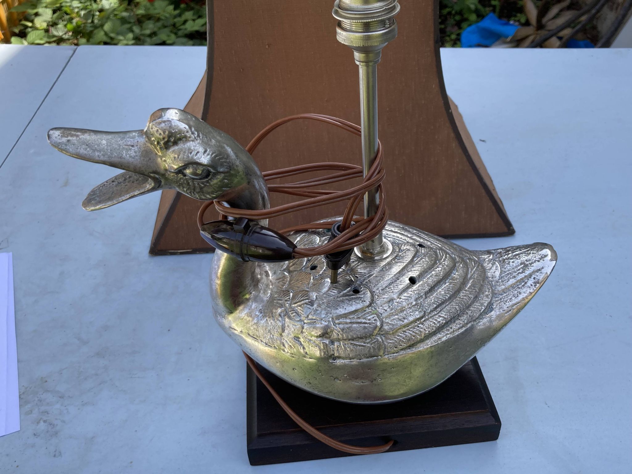 Old vintage lamp representing a duck in silver metal with wooden base